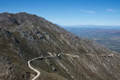 Winding gravel road crossing the steep rocky slopes of Swartberg Pass in the Swartberg Mountains of the Klein Karoo in South Africa.