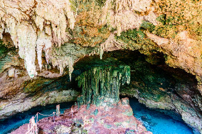 Stalactites and stalagmites above the crystal-clear freshwater pool inside Kuza Cave near Jambiani, Zanzibar, Tanzania.