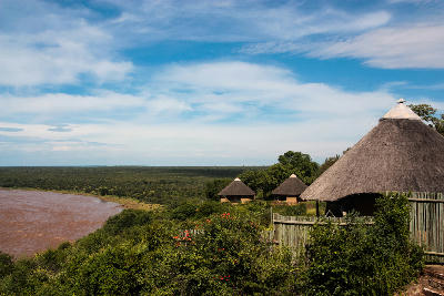 Thatched bungalows overlooking the Olifants River at Olifants Rest Camp in Kruger National Park, South Africa.