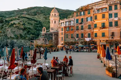 Clock tower of Santa Margherita di Antiochia Church in Vernazza, with colourful village houses and coastal streets in Cinque Terre National Park, Liguria, Italy.