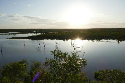 Sunset reflected across Pioneer Dam near Mopani Rest Camp in Kruger National Park, with flooded trees rising from calm water.