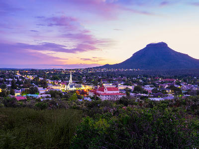 Twilight view of Graaff-Reinet with the Dutch Reformed Church and surrounding Karoo landscapes beneath Spandaukop at sunset.
