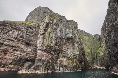 Basalt rock pillar called the Elephant rising from the sea inside the Vestmanna bird cliffs, Streymoy, Faroe Islands.