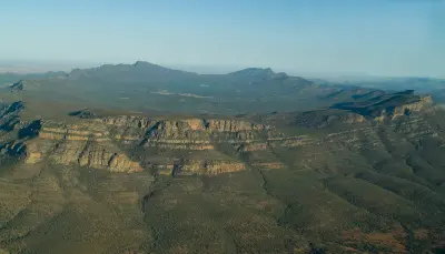 Aerial view of Wilpena Pound's vast mountain basin and surrounding sandstone ridges in the Flinders Ranges, South Australia.