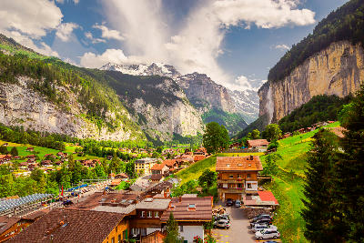 Lauterbrunnen village in a narrow alpine valley with steep cliffs and waterfall, Switzerland.