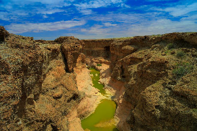 Sesriem Canyon and green river pools carved into the desert landscape of Namibia.