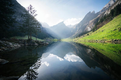 Seealpsee lake reflecting surrounding peaks in the Alpstein mountains, Switzerland.