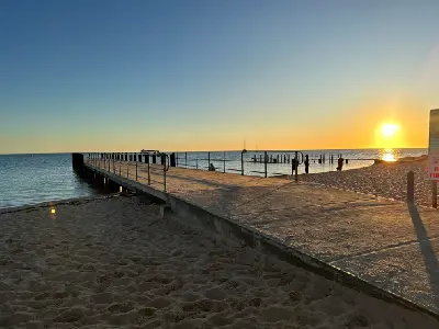 Jetty extending from Monkey Mia beach into Shark Bay at sunset.