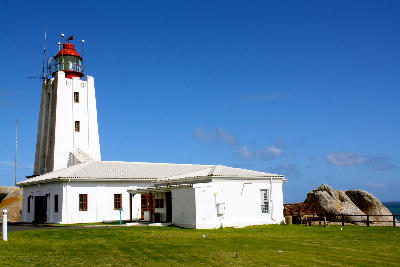 Cape Columbine Lighthouse with adjoining white buildings and granite boulders overlooking the Atlantic coast near Paternoster on South Africa’s West Coast.