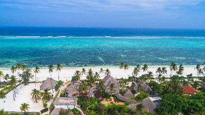 Aerial view of Matemwe Beach featuring palm-fringed resorts, white sand, and the turquoise lagoon of Zanzibar, Tanzania.