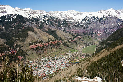 Aerial view of Telluride Valley showing the town below steep mountains and snow-covered peaks in the San Juan Mountains, Colorado.