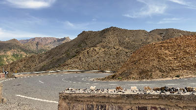 Winding mountain road and dry Atlas landscapes near Tizi n'Tichka Pass in the High Atlas Mountains of Morocco.