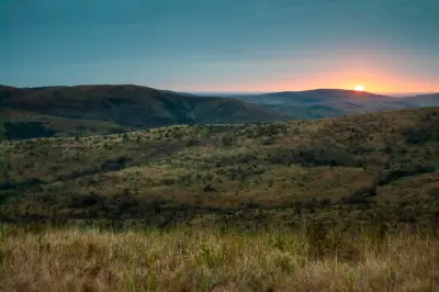 Sunrise across the hills and savanna landscape of Hluhluwe–iMfolozi Park, South Africa.