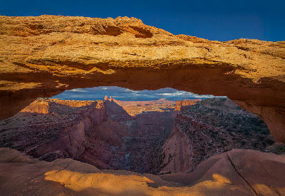 Mesa Arch framing canyon cliffs and desert landscape in Canyonlands National Park Utah