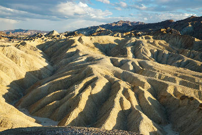 Zabriskie Point badlands at golden hour in Death Valley National Park California showing textured ridges and eroded desert landscape