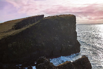 Steep sea cliffs and waves along the coast near Reykjanesviti lighthouse on the Reykjanes Peninsula, Iceland.