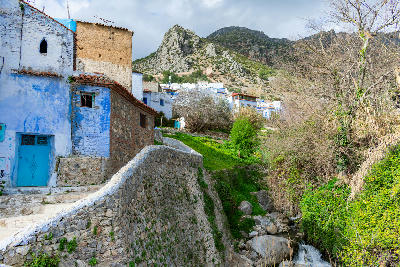 Traditional blue-painted buildings beside the Ras El Maa stream in Chefchaouen, Morocco