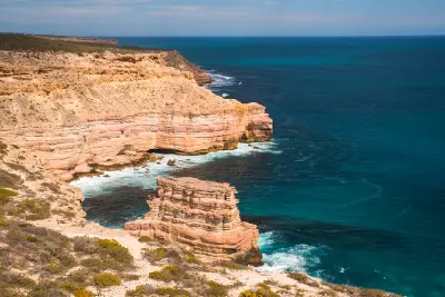 Island Rock stands below layered coastal cliffs with the Indian Ocean stretching beyond.