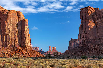 Sandstone buttes and mesas in Monument Valley under a clear blue sky in the Southwest United States.