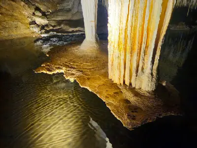 Close view of limestone formations beside the reflective underground pool in Lake Cave, Western Australia.