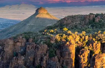 Golden evening light illuminating the cliffs of the Valley of Desolation with a distinctive flat-topped mountain rising above the Great Karoo near Graaff-Reinet, Eastern Cape, South Africa.