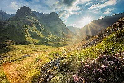 Valley view below the mountains of Glencoe in Lochaber, with layered hills and rugged terrain in the Scottish Highlands.
