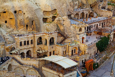 Cave hotels and traditional stone buildings built into volcanic rock in Göreme Town, Cappadocia, Turkey.