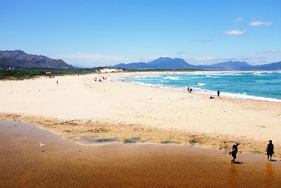 Wide sandy beach and lagoon at Kleinmond beneath the Overberg mountains in South Africa
