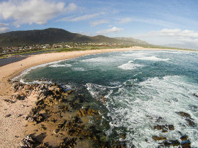 Aerial view of Kleinmond Beach and coastline beneath the Overberg mountains in South Africa