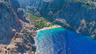 Aerial view of Butterfly Valley with its beach, turquoise water and steep limestone cliffs near Ölüdeniz, Turkey.