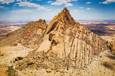 Aerial view of the granite mountain formations of Spitzkoppe in Namibia surrounded by arid desert plains.