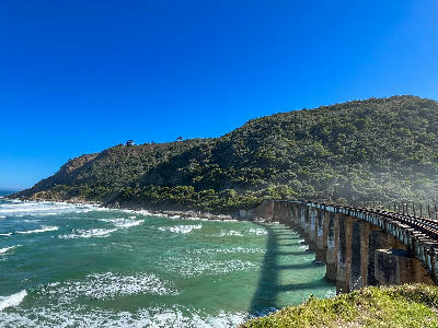 The historic Kaaimans Railway Bridge curves above the Indian Ocean coastline near Wilderness on South Africa's Garden Route.
