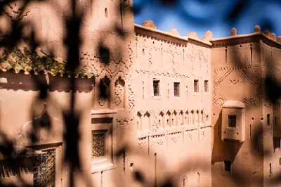 Traditional mud-brick walls and geometric architectural details of Taourirt Kasbah in Ouarzazate, Morocco viewed through shaded foreground framing