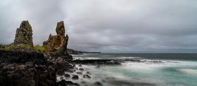 Lóndrangar rock pinnacles rising above the black lava cliffs of the Snæfellsnes Peninsula in western Iceland.
