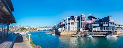 Canal-side homes and moored boats on Thesen Island, showing the waterfront marina environment within Knysna Lagoon on South Africa’s Garden Route.