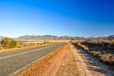Route 62 near Oudtshoorn in the Klein Karoo with the Swartberg Mountains rising beyond the road in the Western Cape.