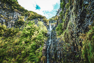Water trickling over mossy rock walls into the lagoon at 25 Fontes in the Rabaçal valley on Madeira Island.