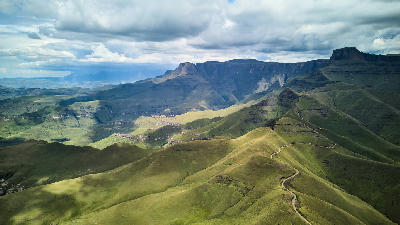 Dramatic aerial landscape of the Amphitheatre escarpment and grassy mountain ridges in the Drakensberg Mountains of South Africa.