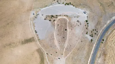 Aerial view of Karakuş Tumulus with its burial mound, surrounding paths and ancient stone columns in Adıyaman, Turkey.
