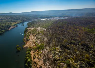 Aerial view of white birds flying above the Mitchell River as it winds through the rugged landscape of the Mitchell Plateau.