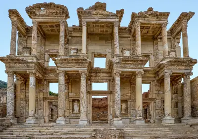 Two-storey marble façade of the Library of Celsus, with rows of columns, carved architectural details, statues and three entrance doorways.