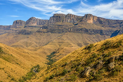 Panoramic landscape of Giant's Castle in the Central Drakensberg, with layered sandstone cliffs, rolling grassy hills and a valley in KwaZulu-Natal, South Africa.