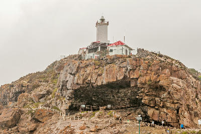 Cape St. Blaize Lighthouse above the archaeological cave and rocky cliffs at The Point in Mossel Bay, South Africa.