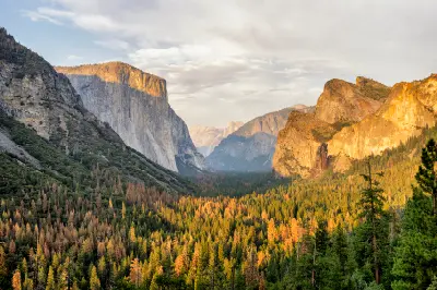Tunnel View Yosemite Valley California showing El Capitan, Cathedral Rocks and forested valley with warm light on granite cliffs.