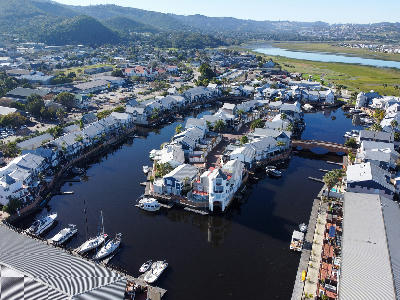 Aerial view of Thesen Island showing waterfront homes, private boat moorings, canal waterways and connecting bridges within the Knysna Lagoon, South Africa.