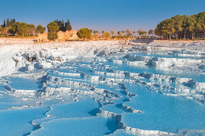 Pamukkale Travertines in Turkey, showing white mineral terraces formed by thermal waters on a hillside landscape.