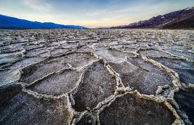 Close-up salt polygon patterns at Badwater Basin in Death Valley with mountains in the background