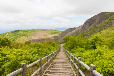 Wooden stairway descending into the volcanic terrain of Mount Usu within the Toya Caldera in Hokkaido, Japan.