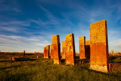 Tall carved medieval gravestones at the historic Ahlat cemetery illuminated by warm evening light in eastern Turkey.