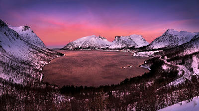 Wide view of Ersfjordbotn fjord with snowy mountains at sunset in Senja